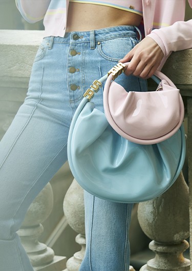 A woman wearing the new two pastel Domino bags