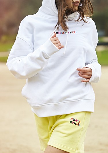 A woman wearing the signature multicolor oversized hoodie and the cotton short shorts