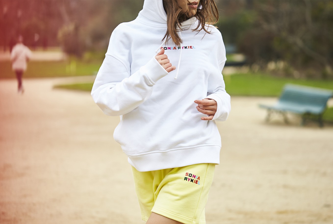 A woman wearing the signature multicolor oversized hoodie and the cotton short shorts